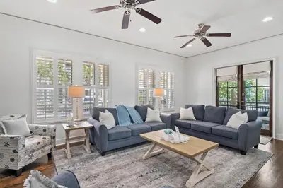 a living room with two blue couches and a table at Southern Coastal in Inlet Beach