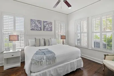 a white bedroom with a bed and windows at Southern Coastal in Inlet Beach
