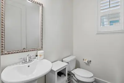 a white bathroom with a sink and a toilet at Southern Coastal in Inlet Beach