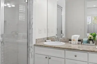 a white bathroom with a sink and a shower at Southern Coastal in Inlet Beach