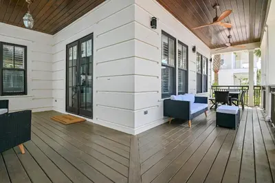 a screened porch with a wooden floor and a ceiling at Southern Coastal in Inlet Beach