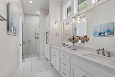 a white bathroom with two sinks and a shower at 28 Dalton Drive in Santa Rosa Beach