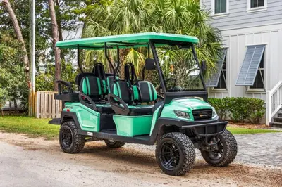 a green golf cart parked in front of a house at 28 Dalton Drive in Santa Rosa Beach