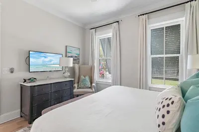 a bedroom with a bed and a tv and windows at 28 Dalton Drive in Santa Rosa Beach