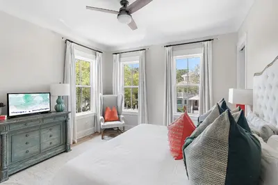 a bedroom with a bed and a tv and windows at 28 Dalton Drive in Santa Rosa Beach