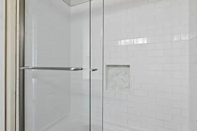 a shower with a glass door in a bathroom at Fintastic in Santa Rosa Beach