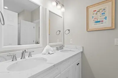 a white bathroom with two sinks and a mirror at Fintastic in Santa Rosa Beach