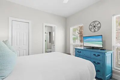 a bedroom with a bed and a tv on a blue dresser at Fintastic in Santa Rosa Beach