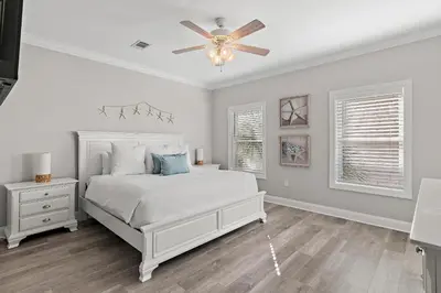 a bedroom with a white bed and a ceiling fan at Emerald Escape in Santa Rosa Beach