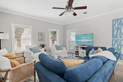 a living room with a blue couch and chairs at Emerald Escape in Santa Rosa Beach