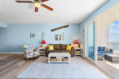 a living room with a couch and a ceiling fan at Spacious 1-Bedroom! Ocean Views & 5 Pools Resort! by Dolce Vita Getaways PCB in Panama City Beach