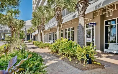 a building with palm trees in front of it at Spacious 1-Bedroom! Ocean Views & 5 Pools Resort! by Dolce Vita Getaways PCB in Panama City Beach