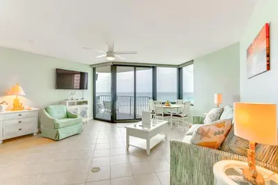 a living room with a couch and a table at Gulf-View Balcony Beachfront Condo in PCB! in Panama City Beach