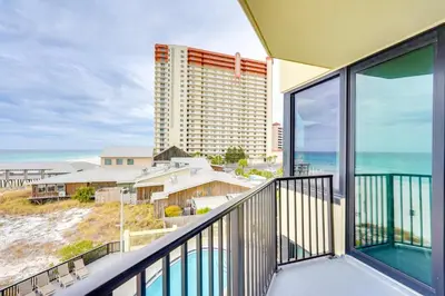 a balcony with a view of a hotel and the ocean at Gulf-View Balcony Beachfront Condo in PCB! in Panama City Beach