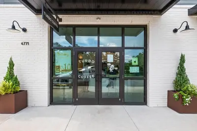 a glass door to a coffee shop with two plants at A Winterpast by the Sea - Gulf Front with Private Pool in Santa Rosa Beach