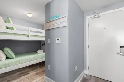 a room with two bunk beds and a closet at Tidewater Escape: 1BR/2BA beachfront condo, sleeps 6, Gulf views & comfort! in Panama City Beach
