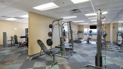 a gym with several tread machines in a room at Tidewater Escape: 1BR/2BA beachfront condo, sleeps 6, Gulf views & comfort! in Panama City Beach