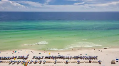 a group of people standing on a beach at Tidewater Escape: 1BR/2BA beachfront condo, sleeps 6, Gulf views & comfort! in Panama City Beach