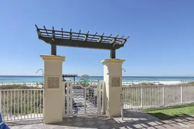 a gate at the beach with the ocean in the background at Shores of Panama 2302 condo in Panama City Beach