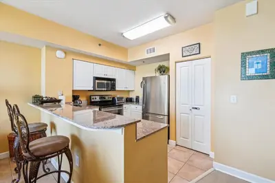 a kitchen with a counter and a refrigerator at Shores of Panama 2302 condo in Panama City Beach