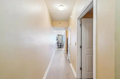 a hallway with a white wall and a white door at Shores of Panama 2302 condo in Panama City Beach