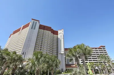 a large building with palm trees in front of it at Shores of Panama 1602 condo in Panama City Beach