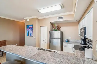 a kitchen with a sink and a refrigerator at Shores of Panama 2325 condo in Panama City Beach