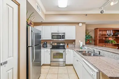 a kitchen with white cabinets and stainless steel appliances at Shores of Panama 2325 condo in Panama City Beach