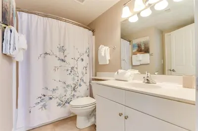 a bathroom with a toilet sink and a shower curtain at Shores of Panama 1601 condo in Panama City Beach