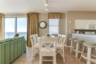 a kitchen and dining room with a table and chairs at Shores of Panama 1601 condo in Panama City Beach