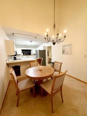 a kitchen and dining room with a wooden table and chairs at Spacious 3BR Family Beach Home 5 Mins to Panama City Beach & Sleeps 9 Hot tub in Panama City Beach