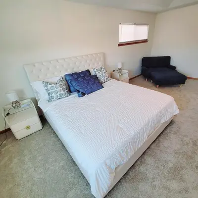 a bedroom with a large white bed with blue pillows at Spacious 3BR Family Beach Home 5 Mins to Panama City Beach & Sleeps 9 Hot tub in Panama City Beach