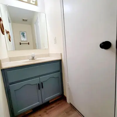 a bathroom with a blue cabinet and a mirror at Spacious 3BR Family Beach Home 5 Mins to Panama City Beach & Sleeps 9 Hot tub in Panama City Beach