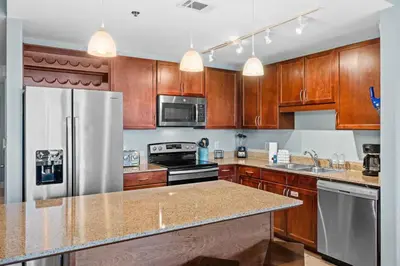 a kitchen with wooden cabinets and a stainless steel refrigerator at Laketown Wharf #0226 in Panama City Beach