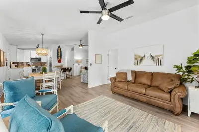 a living room with a couch and a dining room at Aqua Believe It in Panama City Beach