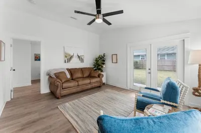 a living room with a couch and a ceiling fan at Aqua Believe It in Panama City Beach