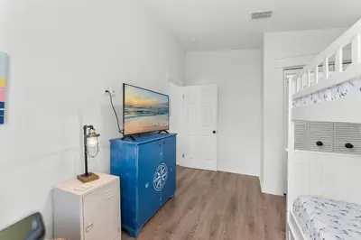 a room with a blue cabinet with a television on it at Aqua Believe It in Panama City Beach