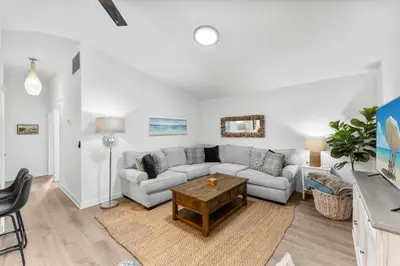 a living room with a couch and a table at Aqua Believe It in Panama City Beach