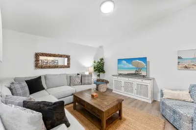 a living room with a couch and a table at Aqua Believe It in Panama City Beach