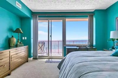 a bedroom with a bed and a view of the ocean at Hidden Dunes 503 in Panama City Beach