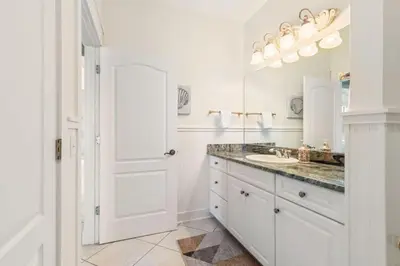 a white bathroom with a sink and a mirror at Beachfront, 4 Bed , White Sands Haven, Penthouse ,Pool in Panama City Beach