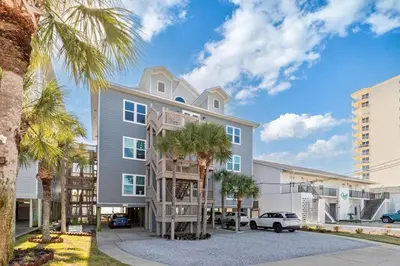 a building with palm trees in front of it at Beachfront, 4 Bed , White Sands Haven, Penthouse ,Pool in Panama City Beach