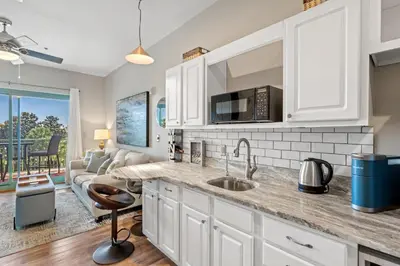 a kitchen with a sink and a living room at Inn at Seacrest 309- Somewhere in the Sun in Inlet Beach