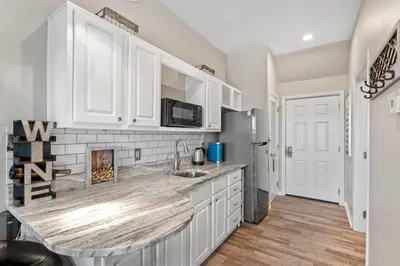 a kitchen with white cabinets and a counter top at Inn at Seacrest 309- Somewhere in the Sun in Inlet Beach