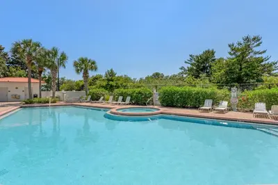 a large swimming pool with chairs and trees at Inn at Seacrest 309- Somewhere in the Sun in Inlet Beach