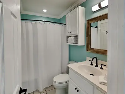 a bathroom with a white toilet and a sink at Sunswept Condominium #210 in Panama City Beach