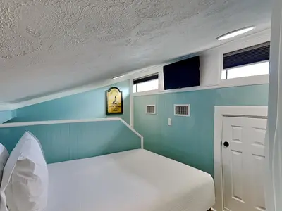 a bedroom with a bed and a clock on the wall at Sunswept Condominium #210 in Panama City Beach