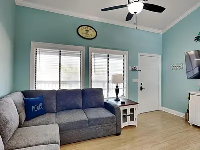 a living room with a couch and a clock on the wall at Sunswept Condominium #210 in Panama City Beach