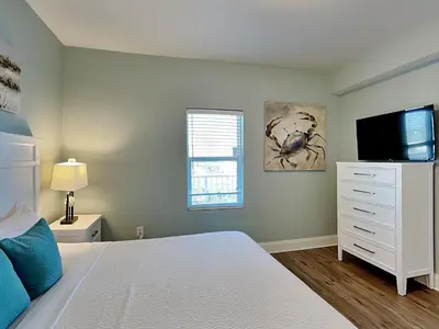 a bedroom with a white bed and a tv at Laketown Wharf #913 in Panama City Beach