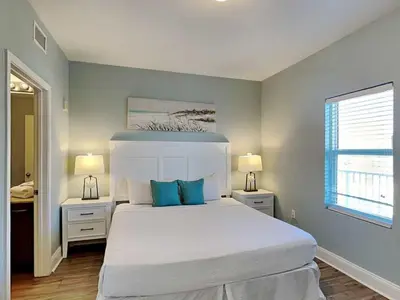 a bedroom with a large white bed with blue pillows at Laketown Wharf #913 in Panama City Beach